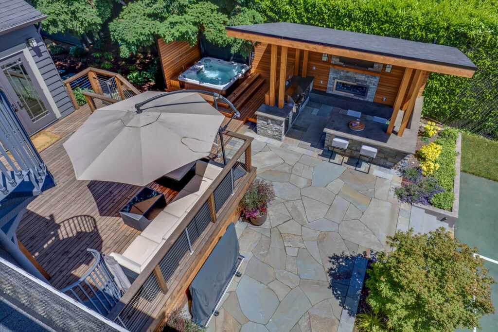 Aerial view of backyard with deck, hot tub, and kitchen.