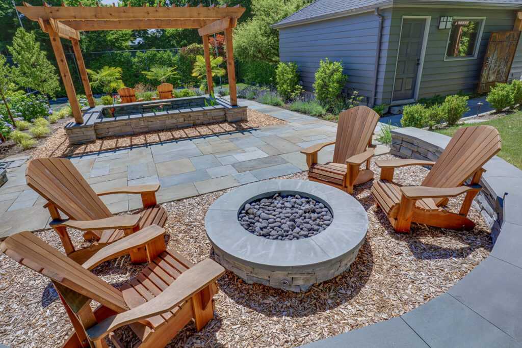 Outdoor patio with fire pit and wooden chairs