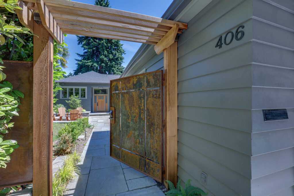 Elegant home entrance with rustic gate and garden