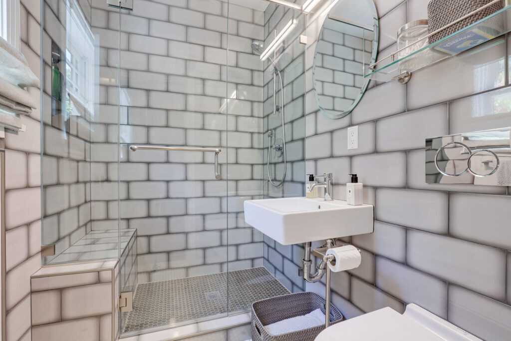 Modern bathroom with white tiles and glass shower