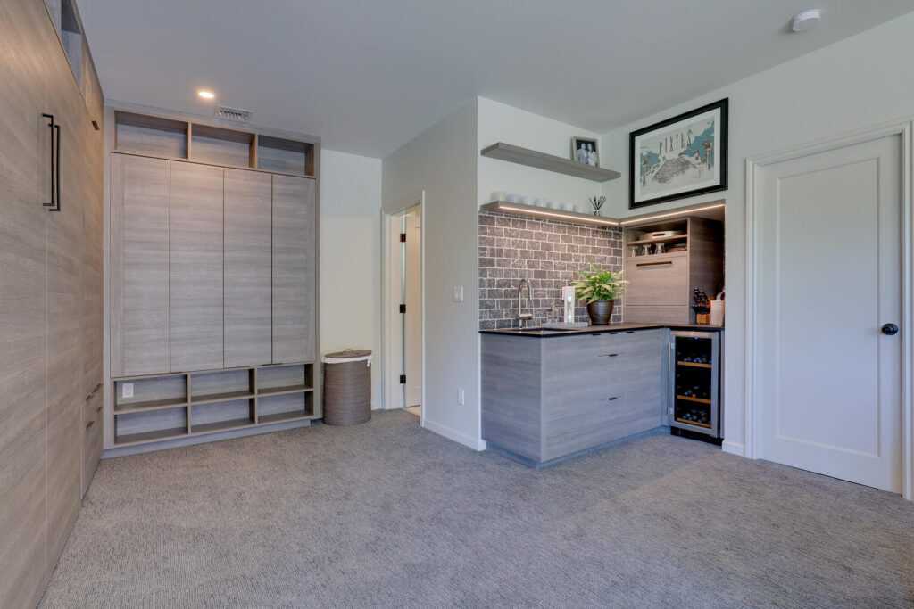 Modern kitchenette with gray cabinets and brick backsplash
