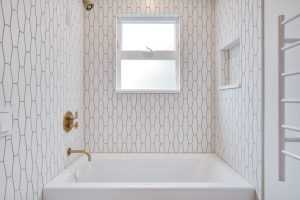 Modern bathroom with geometric tiled walls and bathtub