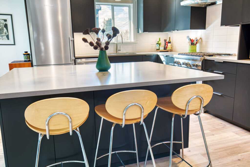 Modern kitchen with stools and stainless steel appliances