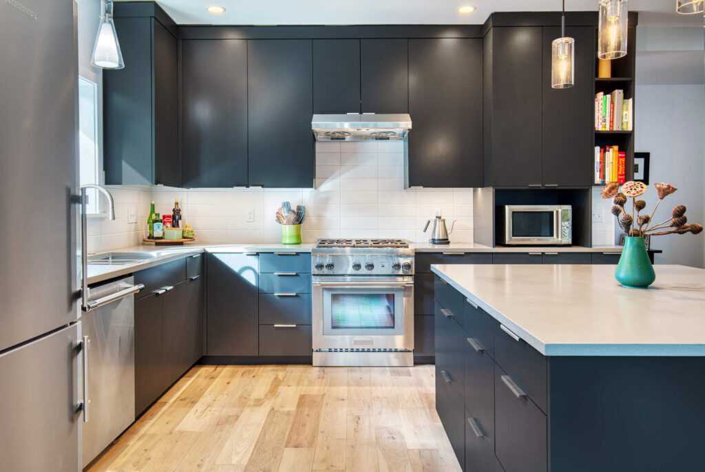 Modern kitchen with black cabinets and wooden floor