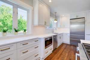 Modern kitchen interior with white cabinets and appliances