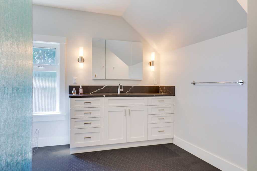 Modern bathroom with white cabinets and black marble countertop