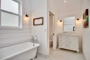 Modern bathroom with clawfoot tub and white vanity