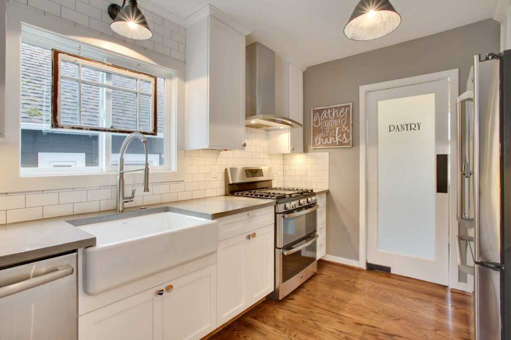 Modern kitchen with white cabinetry and stainless appliances