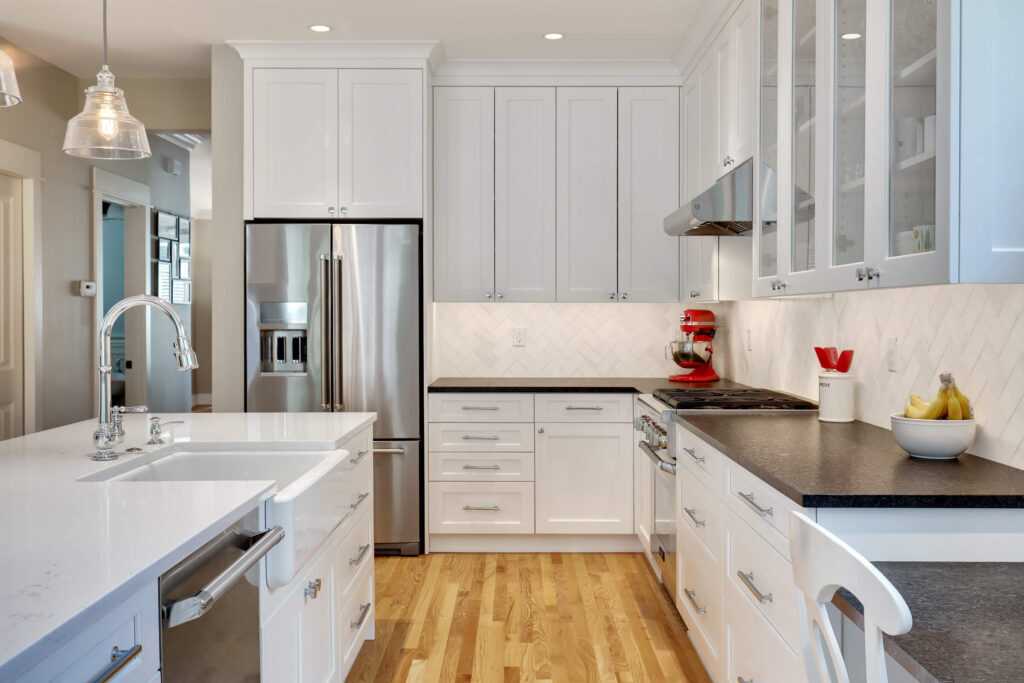 Modern kitchen with white cabinets and stainless appliances.