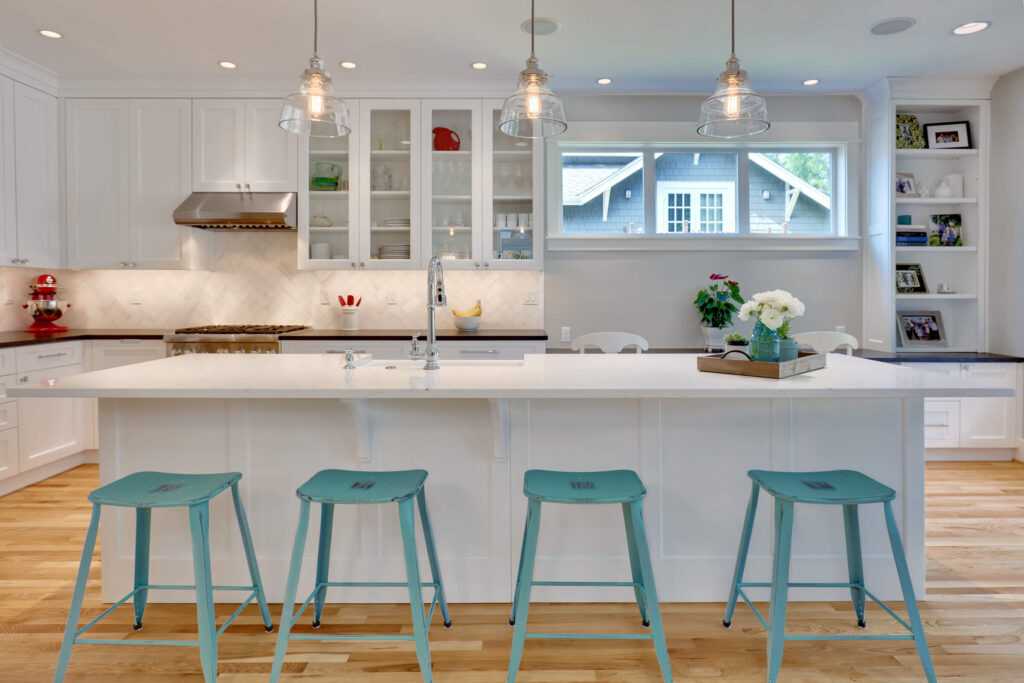 Bright modern kitchen with teal bar stools.