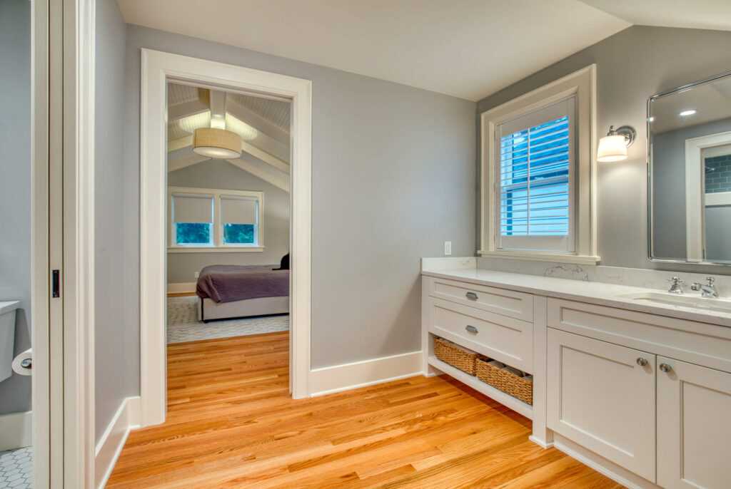 Modern bathroom leading to bedroom with wooden floors