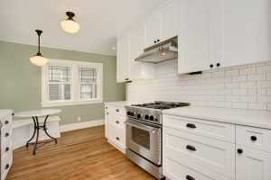 Bright kitchen with white cabinets and wooden floors