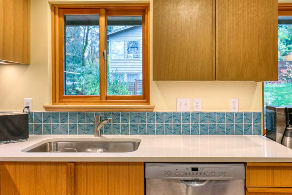 Modern kitchen with teal backsplash and wooden cabinets