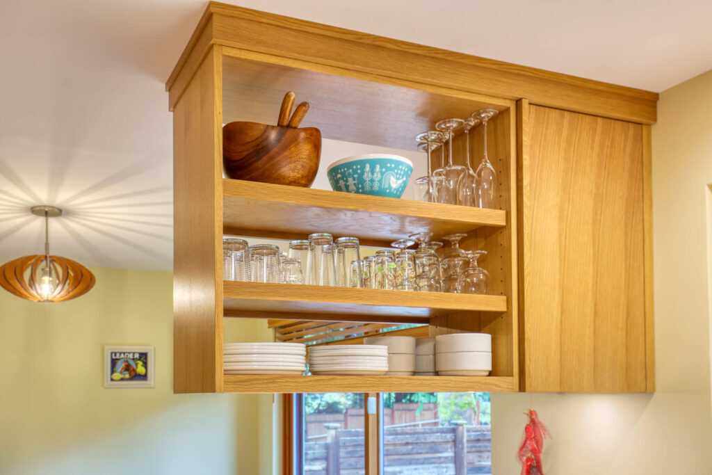 Well-organized kitchen shelves with various dishware and glasses