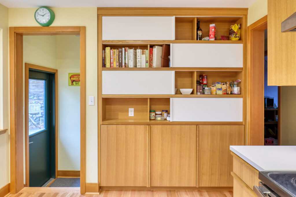 Modern kitchen pantry with organized shelves and books