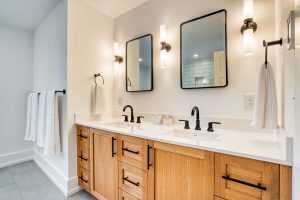Modern bathroom with wooden cabinets and dual mirrors