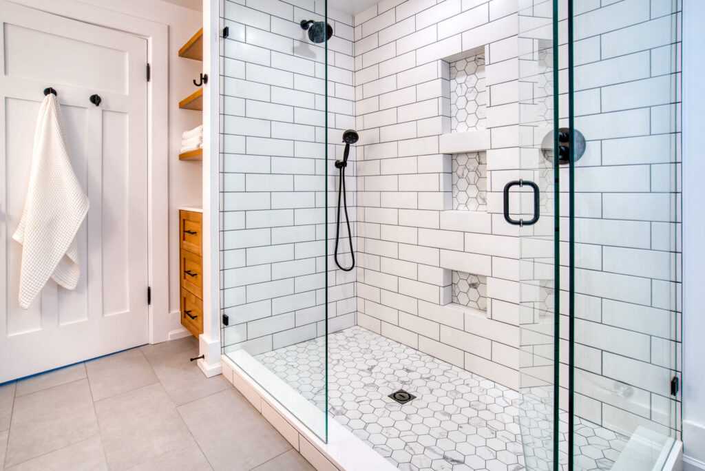 Modern white tiled bathroom with glass shower door