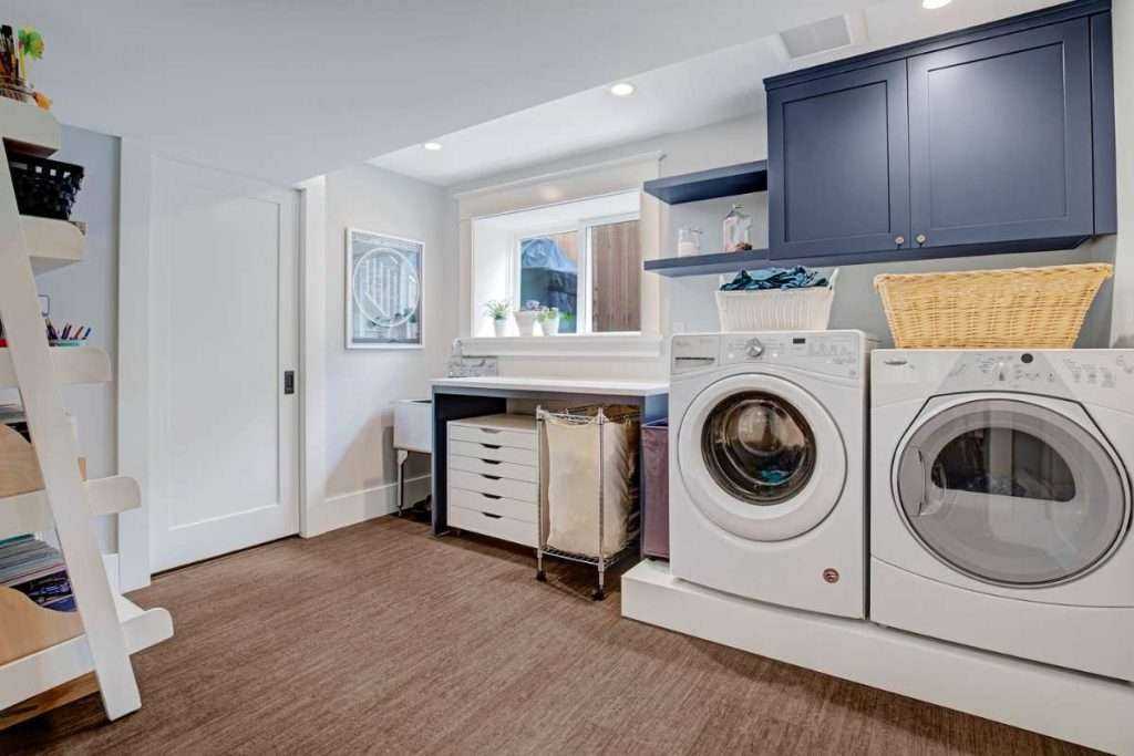 Modern laundry room with washer, dryer, and cabinets