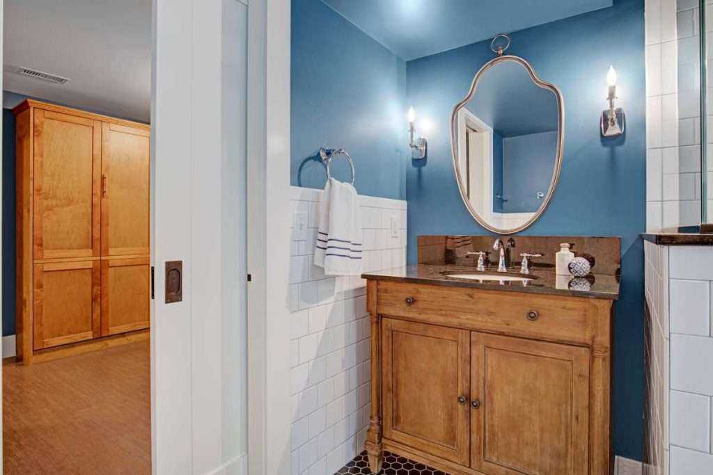 Elegant bathroom with blue walls and wooden vanity