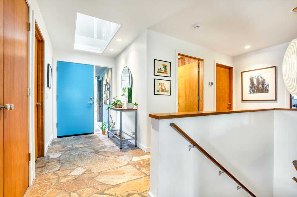 Bright home entryway with blue door and skylight