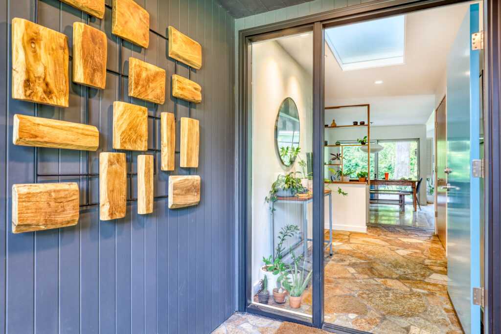 Stylish entryway with wooden art and lush plants