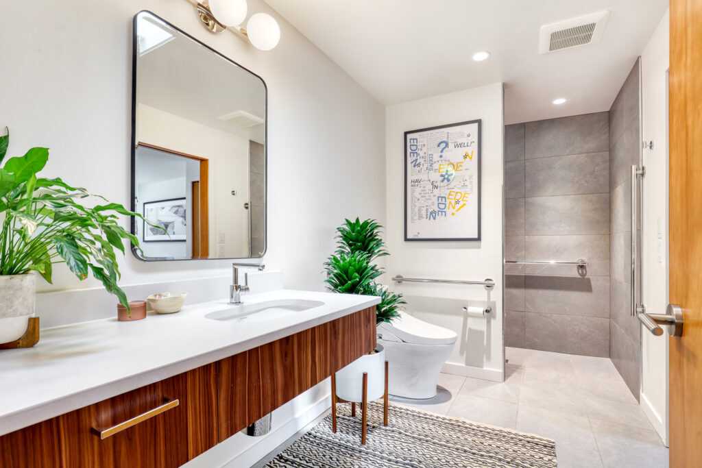 Modern bathroom with decorative plants and framed poster
