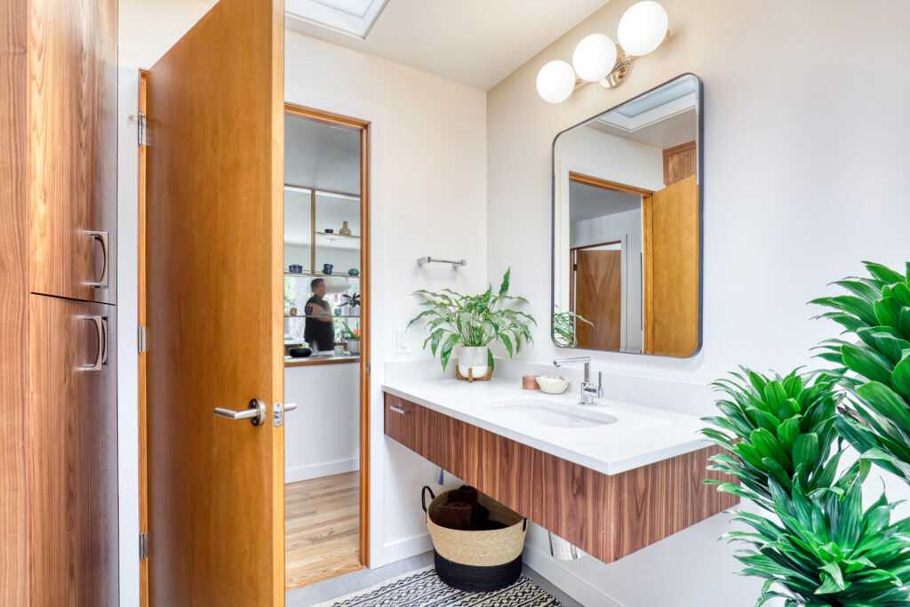 Modern bathroom with plants and mirrored reflections