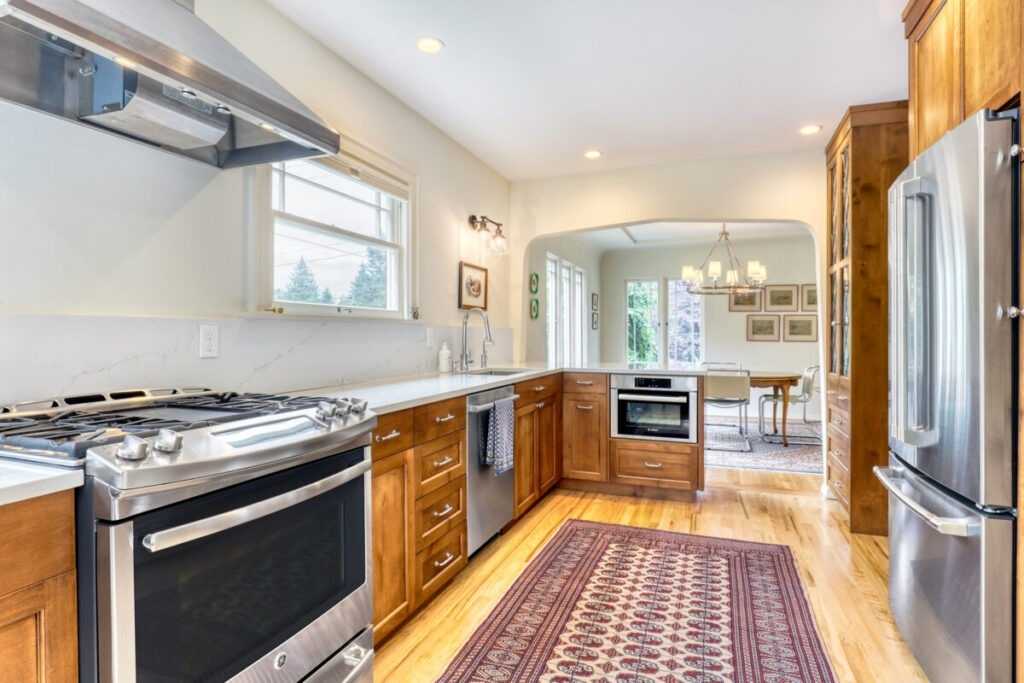 Bright modern kitchen with wood cabinets and steel appliances