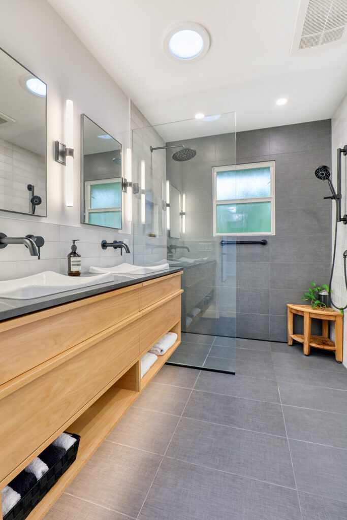 Modern bathroom with double sink and glass shower.