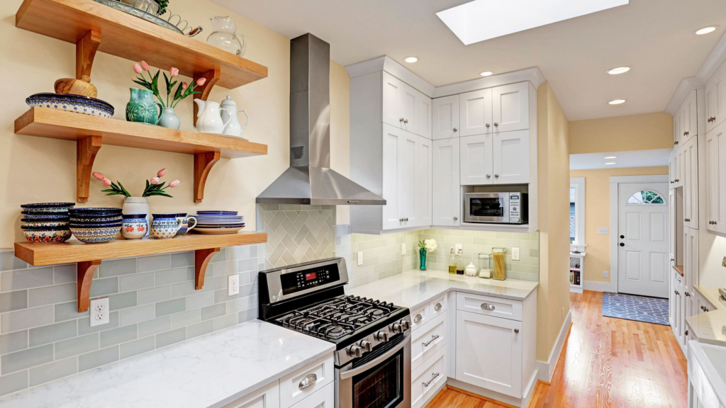 Bright galley kitchen from a Seattle remodel featuring open shelving, gray subway tile, and white shaker cabinetry.