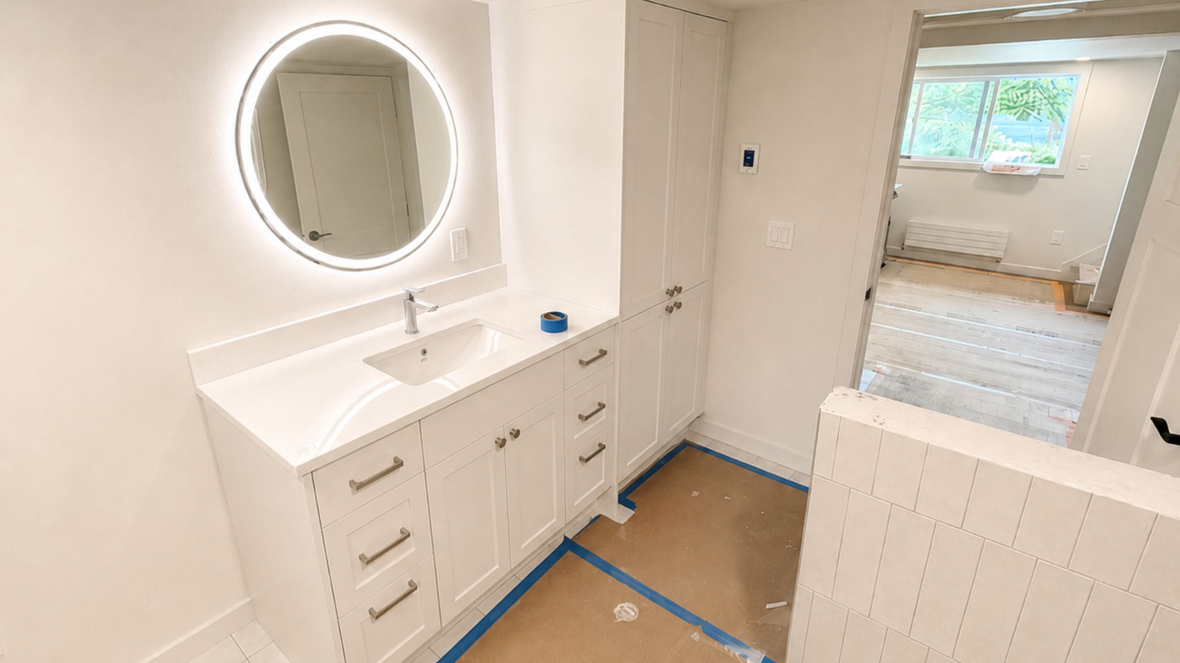 Work in progress from a bathroom remodeling cost estimate: shaker vanity, undermount sink, tall linen cabinet, and tiled shower wall.